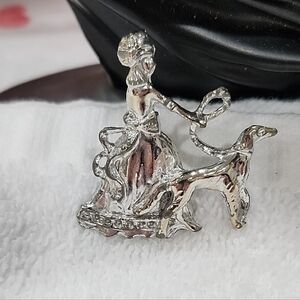 VINTAGE SILVERTONE BROOCH of WOMAN in DRESS WALKING GREYHOUND DOG